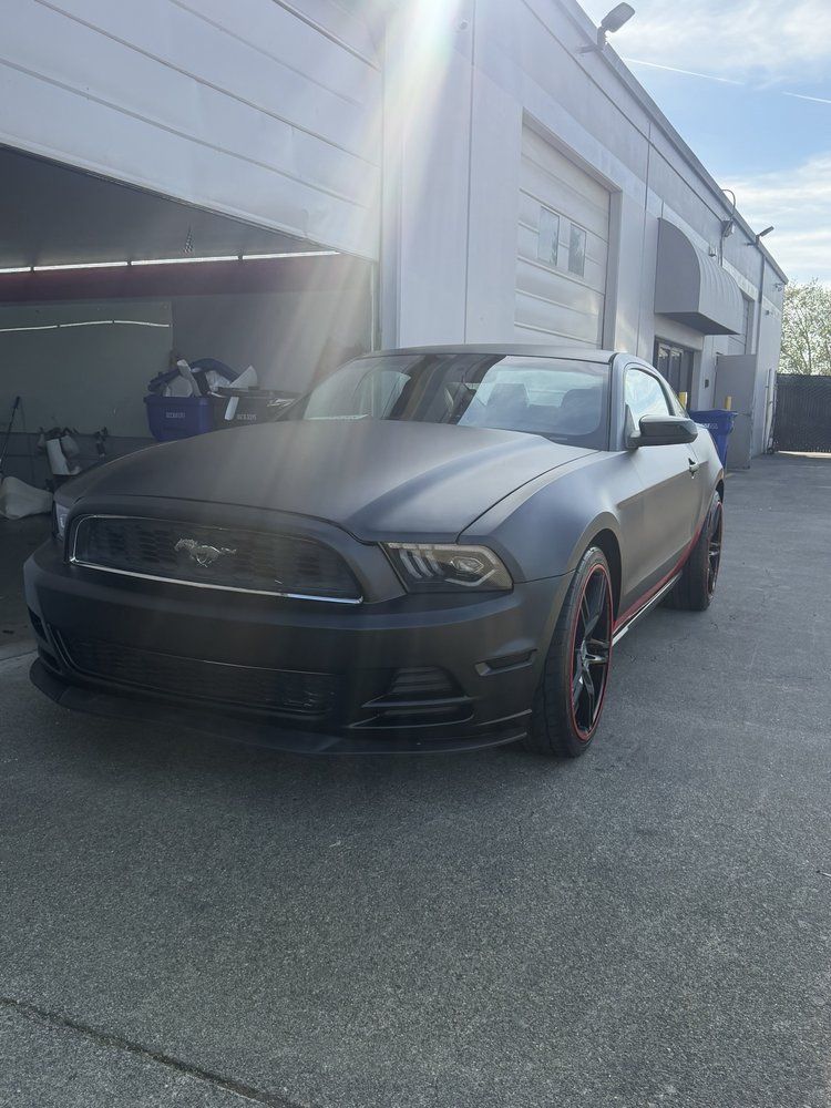 Aaron P. matte black custom wrapped Mustang front