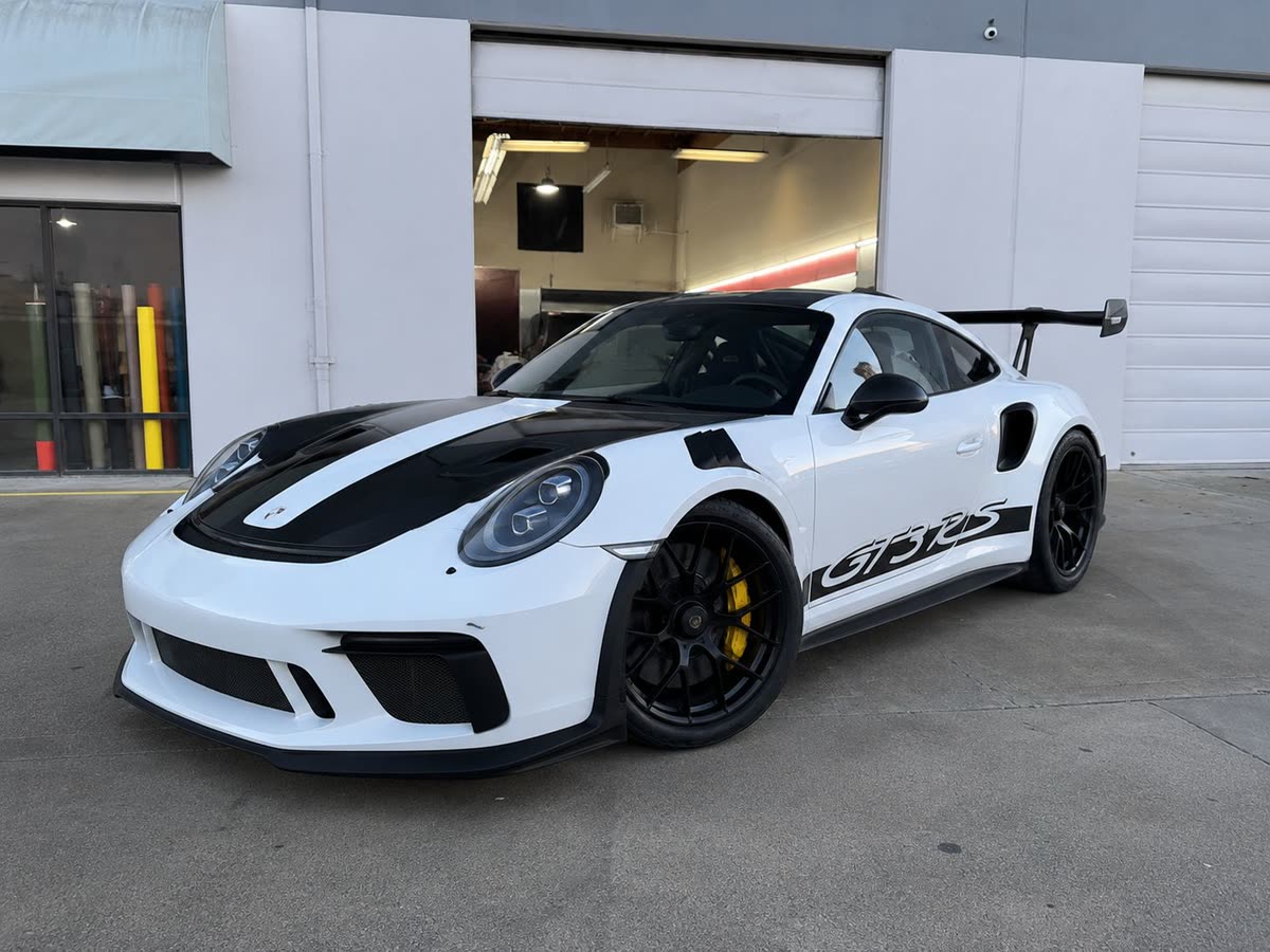 White Porsche 911 GT3 RS with black stripes outside the Hayward studio