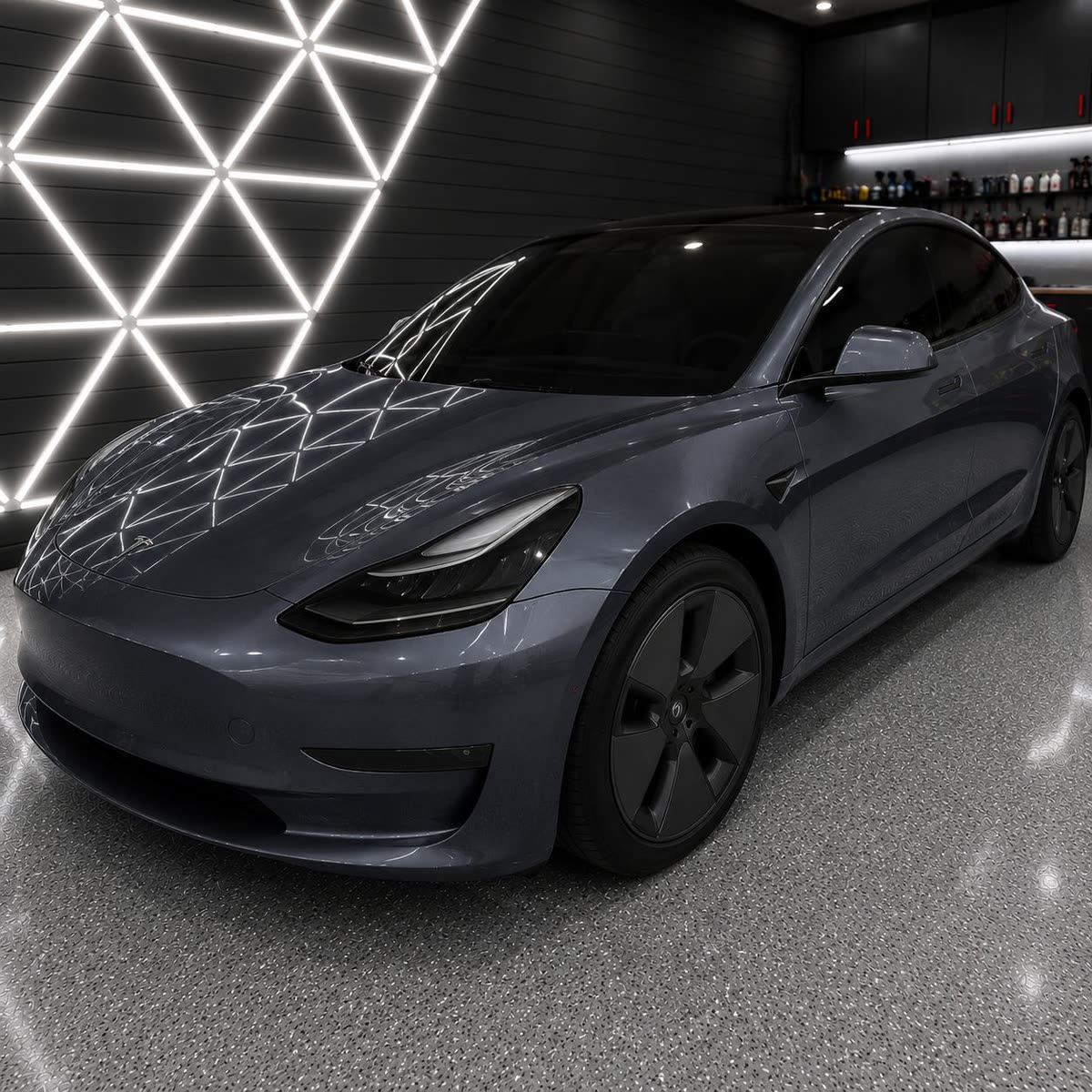 Grey Tesla Model 3 under studio lighting with reflections running clean across the hood
